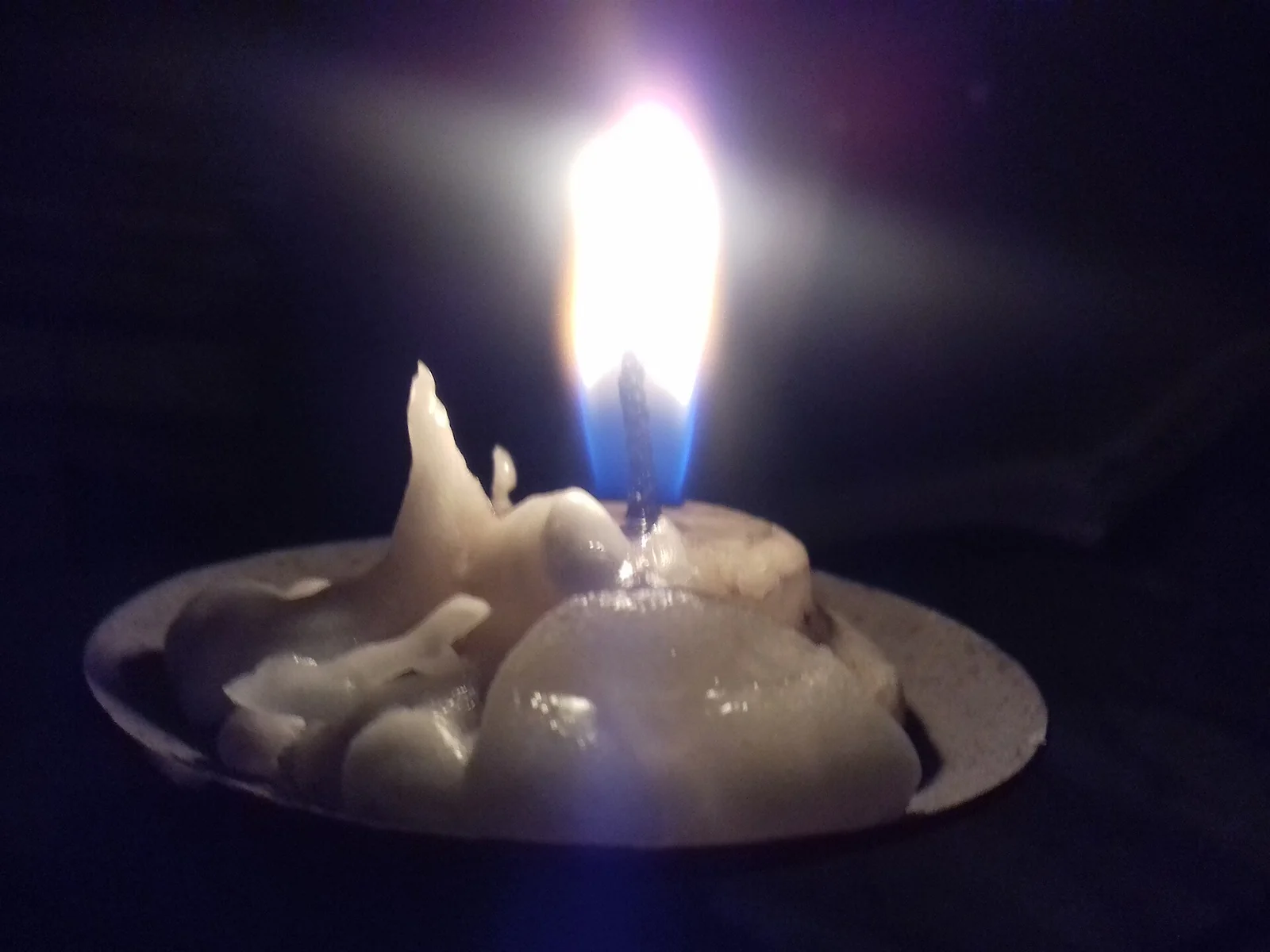 Bougie allumée diffusant une lumière douce dans la pénombre